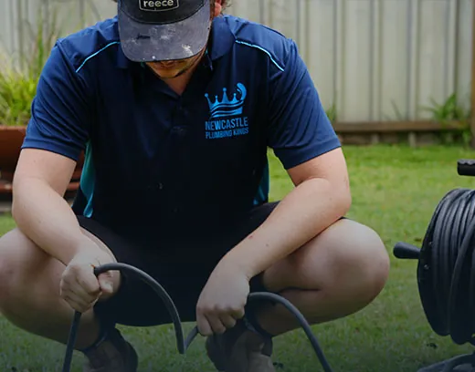 Plumber working a drain-clearing machine