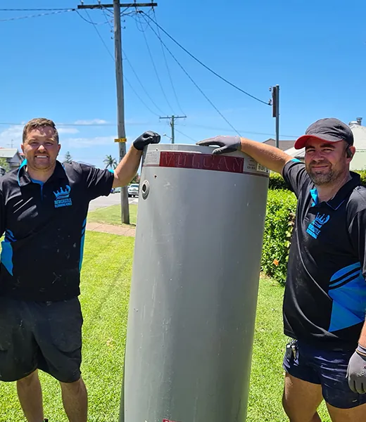 Two plumbers removing an old hot water tank
